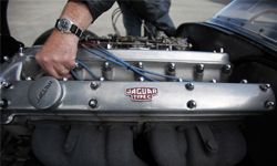 Historic car enthusiast Ian Sumner checks the engine of a Jaguar D-Type replica classic car which is displayed at the annual RNAS Yeovilton Air Day in Yeovil, England.