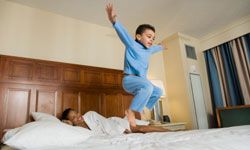 Boys playing in bedroom bed.