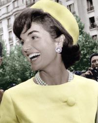 During her 1961 official visit to Paris, Jacqueline Kennedy sported an Alaskine (wool and silk) suit created by Oleg Cassini and pillbox hat created by Roy Halston Frowick.