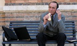 businessman eating lunch on a bench 
