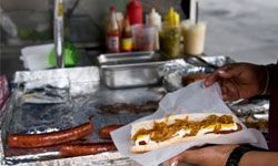 hot dog vendor preparing hot dog