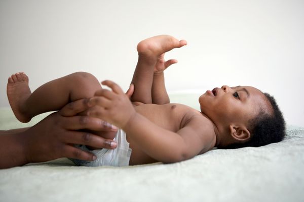 Baby lying down looking at his toes.