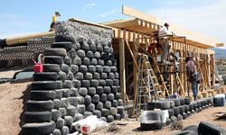 在新墨西哥州陶斯的大世界地球船社区，你可以看到这艘地球船的轮胎和瓶子。＂width=