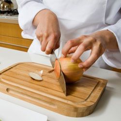 The first step of this cut is lopping off the top and bottom of the fruit or vegetable.