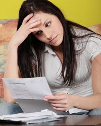 Frustrated woman looking at bills