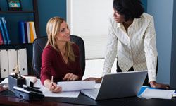 Woman and lawyer looking at paperwork in office