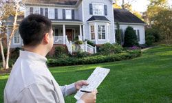 Man with paper outside of house