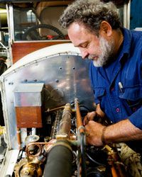 Mechanic working on classic car in garage