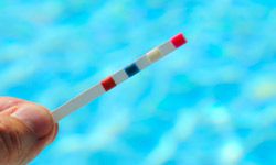 Testing your pool's pH level is as simple as dipping a strip of paper in the water.
