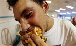 Guy eating double cheeseburger