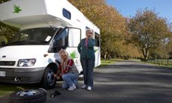 Retired couple changing tire on RV