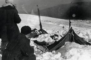 Investigators at the site of the Dyatlov Pass incident examine the campers’ tent, which had been cut open from the inside.  