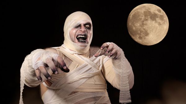 Men in costume on Halloween night against black backdrop.