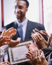 Hands applauding man with certificate