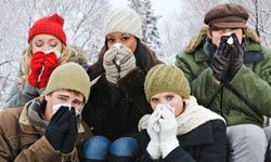 group of people blowing their noses while sitting outside in winter