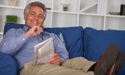 Man on couch with newspaper