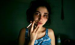 Girl smoking cigarette in dark room