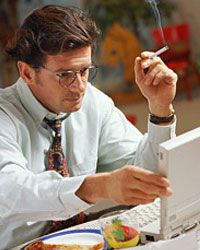 Man smoking and working at computer