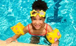 Girl with floaties and goggles in swimming pool