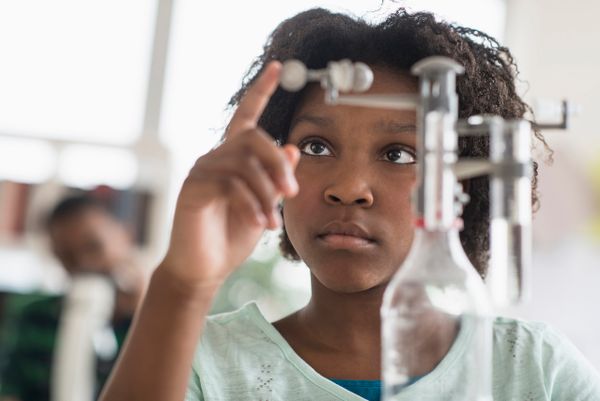 A girl does a science experiment in a lab.