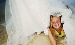 little girl hiding under bride's skirt