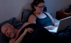 woman working on laptop in bed