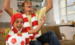 Father and son watching soccer on TV