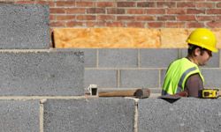 A contractor installing concrete blocks.