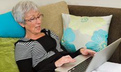 woman reading online news, woman on computer, woman on laptop