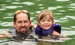 教你的孩子游泳是一个在假期债券的好方法。“border=
