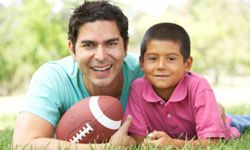 father and son playing football