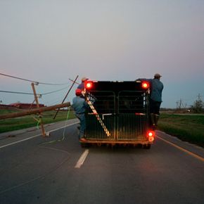 Men riding on the outside of a trailer