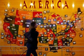 A passenger rolls past a map of the United States of America at Denver International Airport.