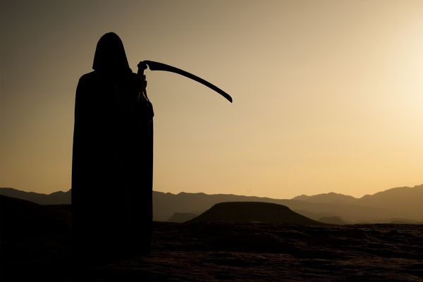 Silhouetted men outdoors backlit by sunset.