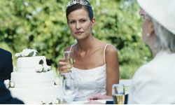 worried-looking bride sitting next to cake