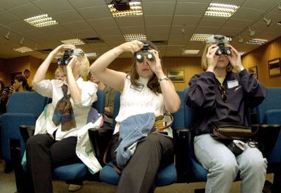 Marcie Todaro (L) Kellie Hill (C) and Kim Helgeson learn how to use a pair of night vision goggles during a spouse's orientation day at the 37th Airlift Squadron, 86th Air Lift Wing.