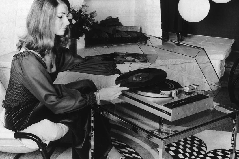 A model demonstrates the then-innovative automatic turntable at an electronics show in 1974. The turntable placed the pick-up on the record, lifted it off when it reached the end of the side and stopped the motor. Madina Gajimuradova /EyeEm/Getty Images