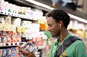 Man inspects yogurt label in grocery store