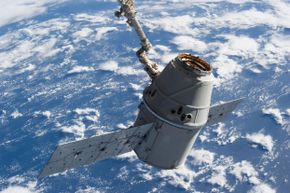 胜利!这张照片以地球为背景，拍摄于2013年3月，Dragon-2被国际空间站的遥控系统(Canadarm2)抓住。＂border=