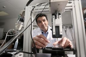 Dr. Darryl D'Lima, an orthopedic specialist, works with a bioprinter he helped to develop located in the Shiley Center for Orthopedic Research & Education at Scripps Clinic. D' Lima has enlisted bioprinting in his cartilage regeneration research.”width=