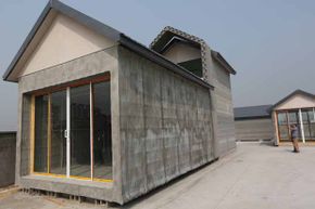 Two people visit a 3-D-printed house in Shanghai, China. The manufacturer says it can make 10 of these houses in a day.