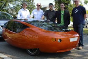 Members of the Urbee 2 design team pose with the Urbee 2, a 3-D printed car.