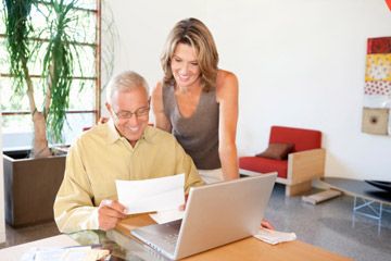 Mature man and woman at laptop. 