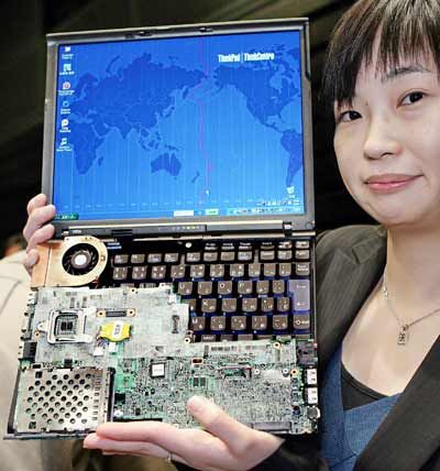 Lenovo Japan employee Kaori Kimura displays the new ultra-light notebook PC 'ThinkPad X60s', equipped with Intel's Core Duo processor, 12.1-inch LCD display and 30GB HDD on its slim body weighing 1.16kg.