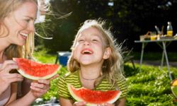 mother and daughter eating watermelon