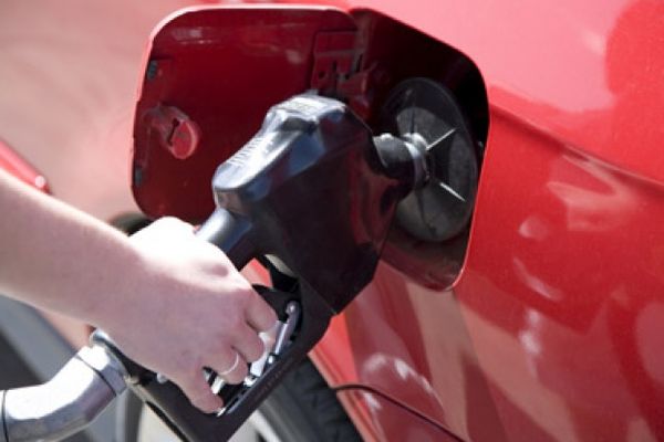 A woman pumping gas.