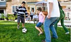 family playing soccer in yard