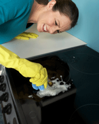 Woman struggling to clean a glasstop stove