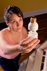 A woman changes her CFL.