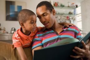 father reading a book to young son